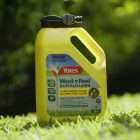 Yellow lawn weed killer bottle labeled 'Yates Weed'n'Feed Buffalo Lawn' on grass outdoor setting. - Quality Garden Supplies
